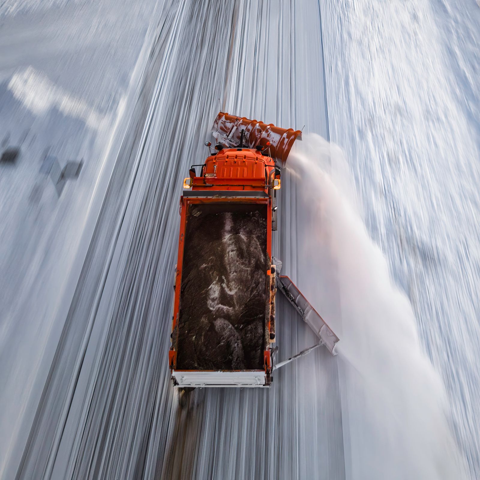 Aerial view of a snowplow clearing a snow-covered road