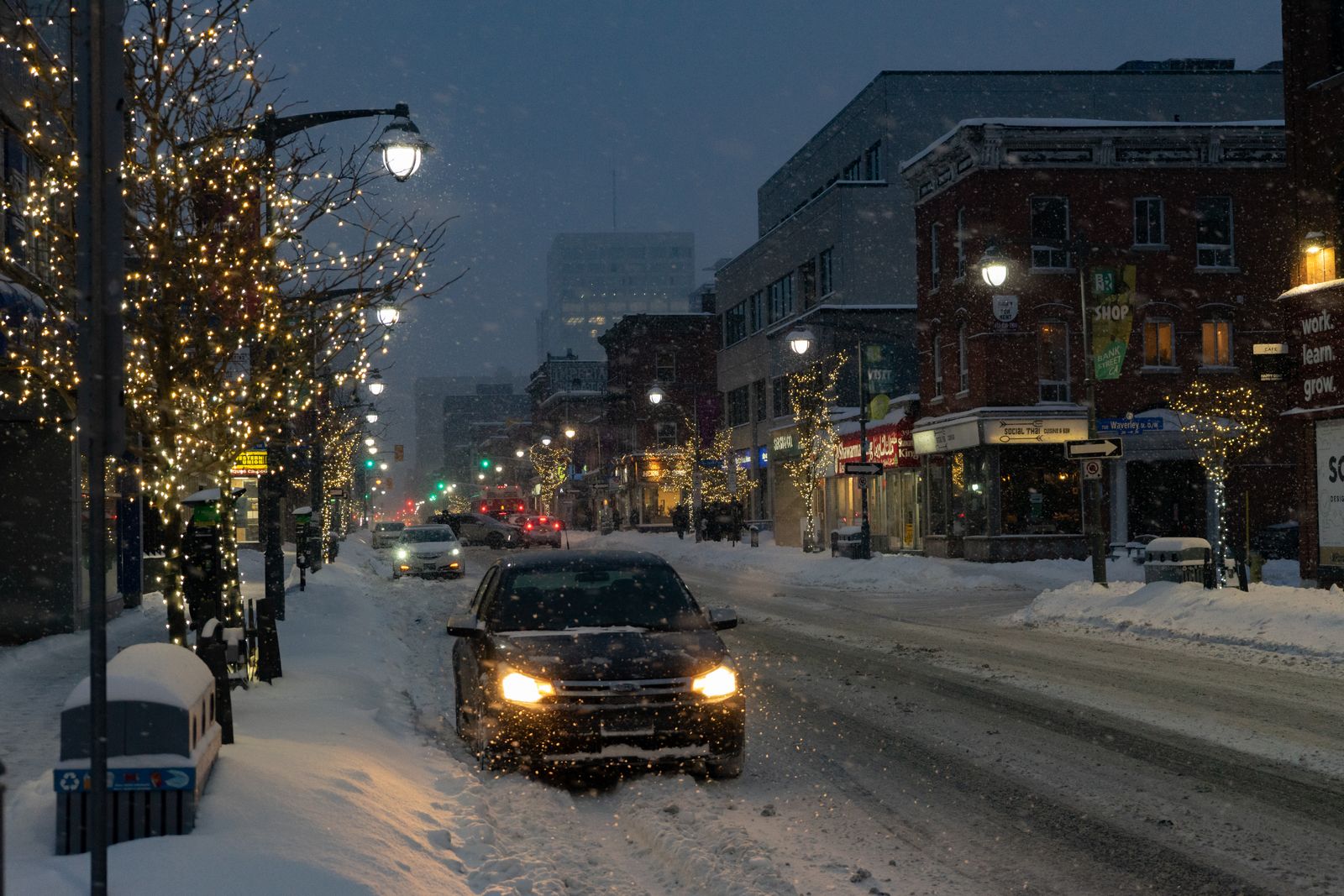 Snow-covered Ottawa street glowing under festive lights at night